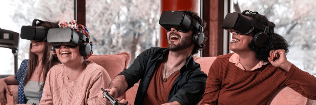 Grupa osób oglądająca film w nowoczesnych, lekkich goglach VR na głowie, co demonstruje komfort użytkowania i zaawansowaną technologię sprzętową.