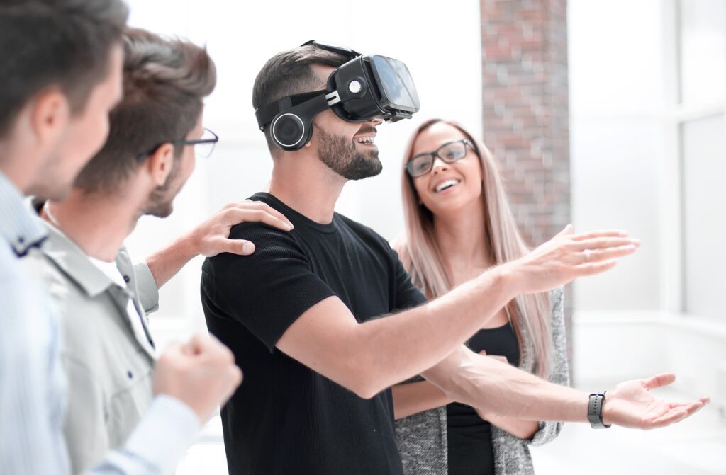 Menedżer w nowoczesnym biurze korzystający z gogli VR do interaktywnej prezentacji biznesowej, zastępującej tradycyjne slajdy.